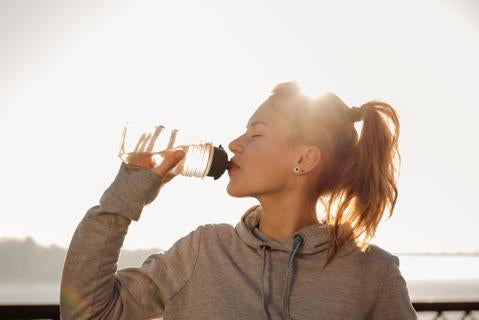 Young woman drinking water - blog by O2 Living makers of living health and wellness cbd and hemp extract